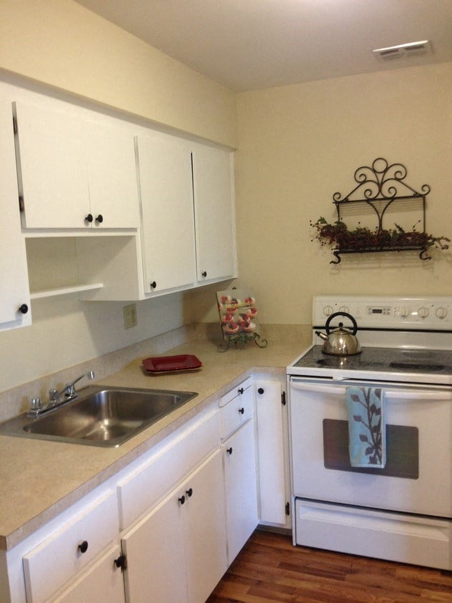 a kitchen with white cabinets and a stove and a sink