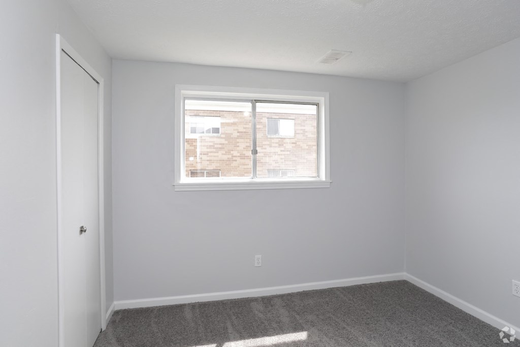 an empty room with a window and a door