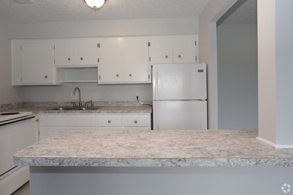 a kitchen with white cabinets and a granite counter top