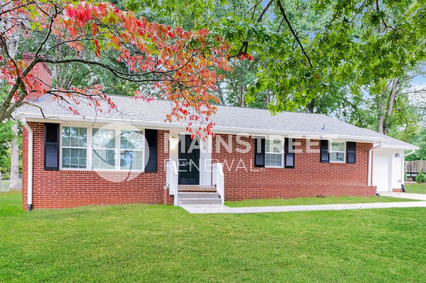 a brick house with a lawn and a tree