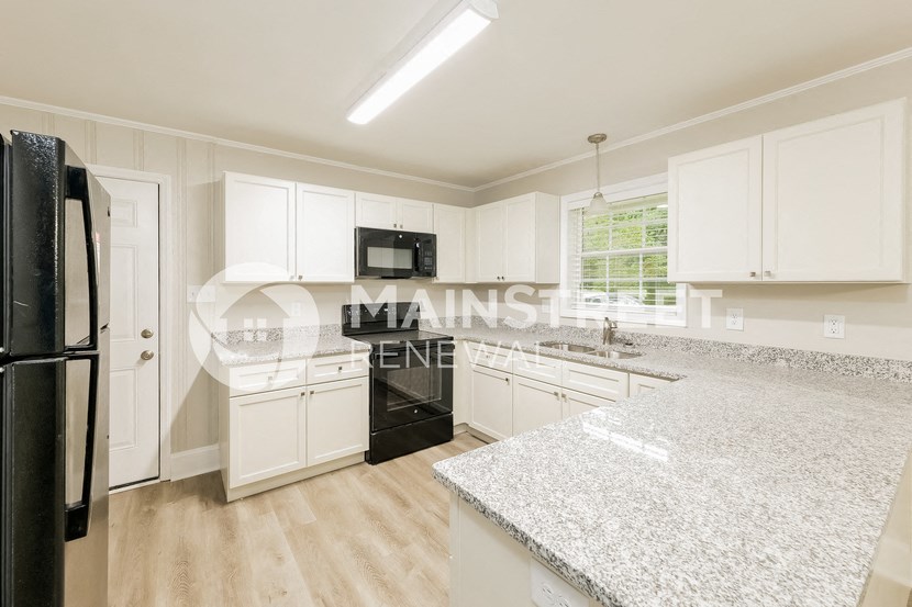 a white kitchen with marble counter tops and white cabinets