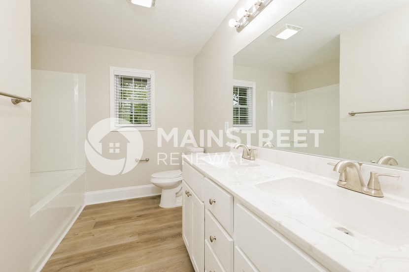 a renovated bathroom with a large white sink and a toilet