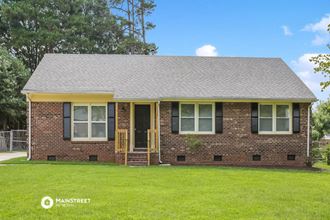 a brick house with a yard in front of it