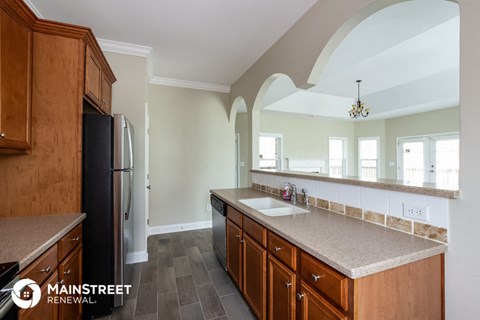 a large kitchen with a sink and a refrigerator