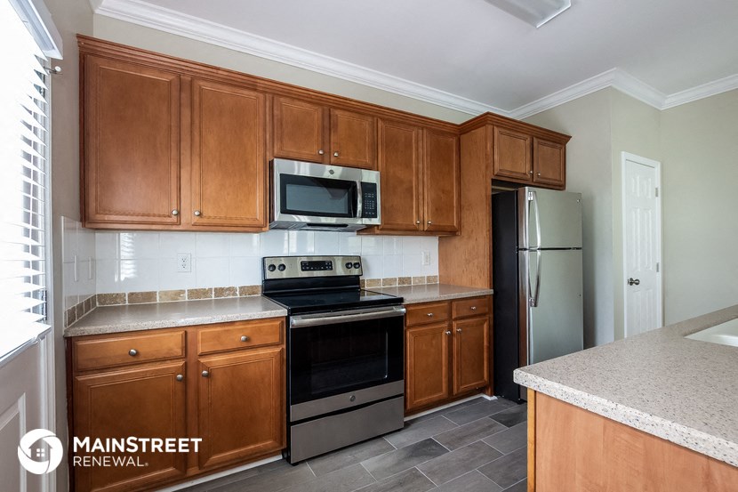 a kitchen with wooden cabinets and stainless steel appliances