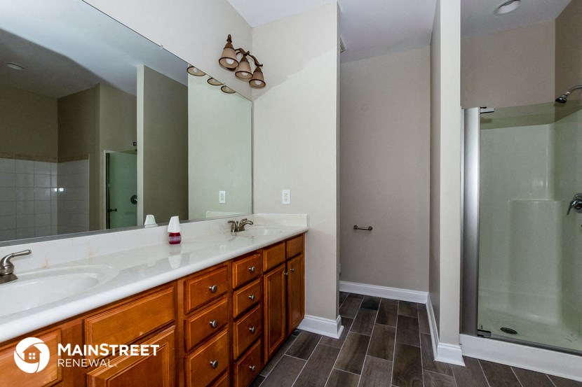 a bathroom with a large mirror and a sink and a shower