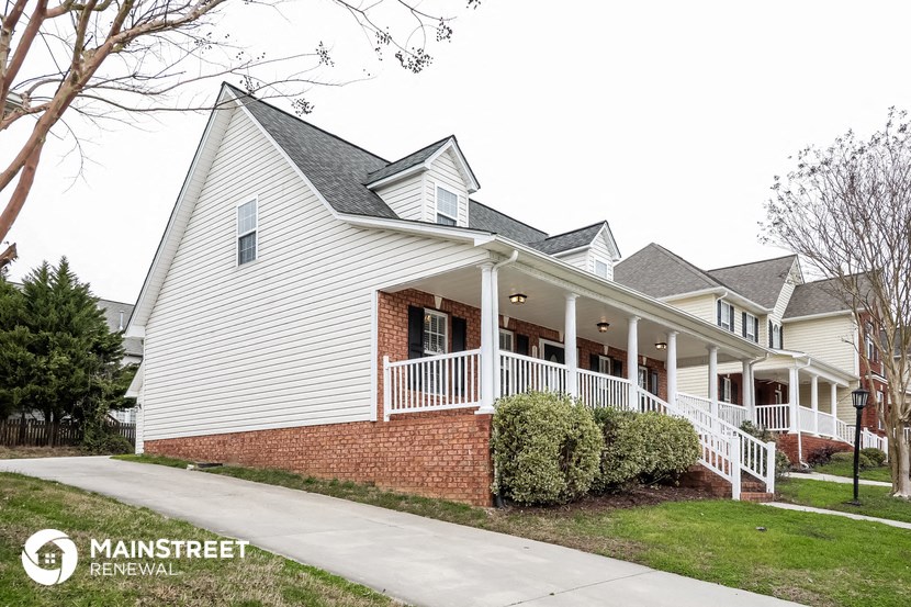a white house with a porch and a sidewalk