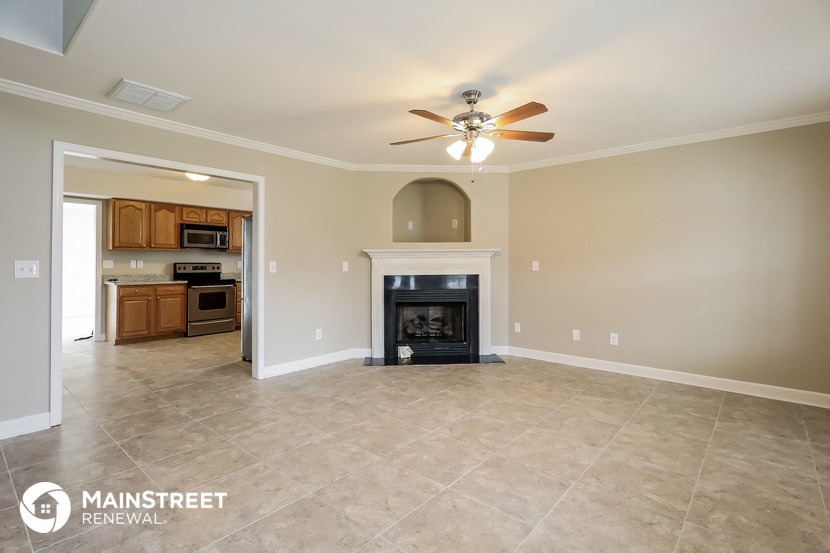 a living room with a fireplace and a ceiling fan