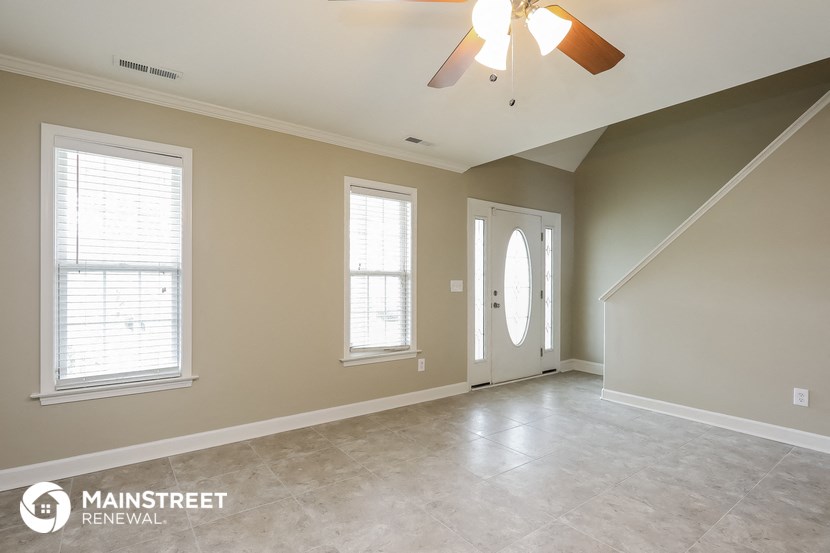 the living room of a new home with a ceiling fan