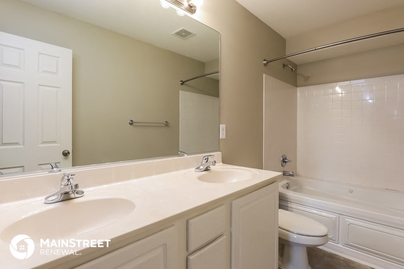 a bathroom with two sinks and a tub and a toilet