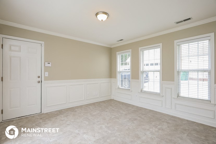 a dining room with white walls and a white door