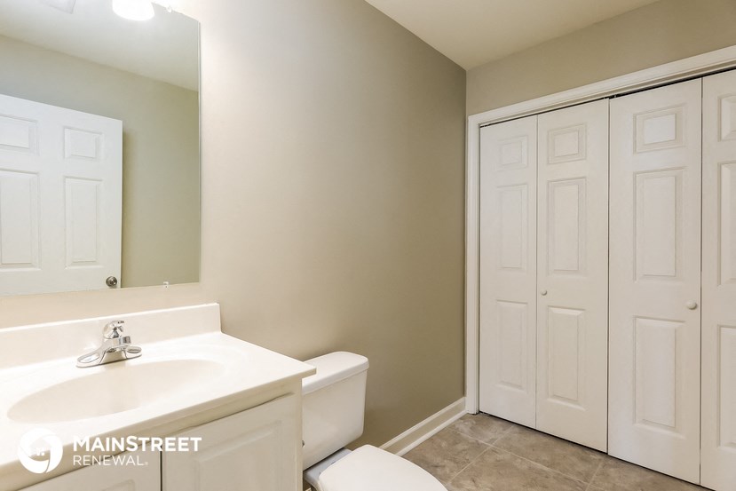a bathroom with a toilet and a sink and a mirror