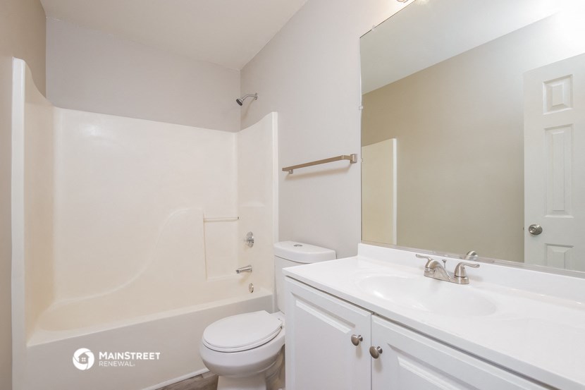 a bathroom with a sink toilet and a mirror