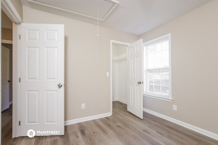 an empty room with two doors and a window