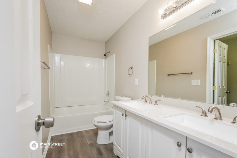 a bathroom with a large mirror and a sink and a toilet