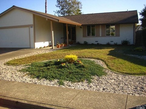A house with a brown roof and a white garage door.