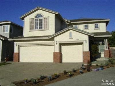 A large house with a white garage door is for sale.