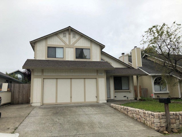 A two-story house with a garage and a driveway.