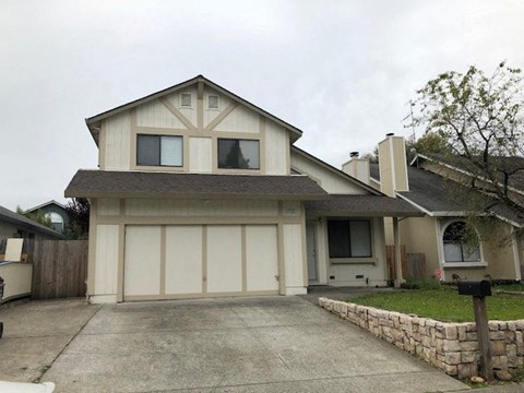 A two-story house with a garage and a driveway.