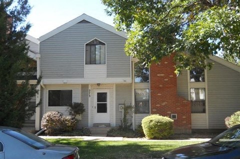 a white and gray house with cars parked in front of it