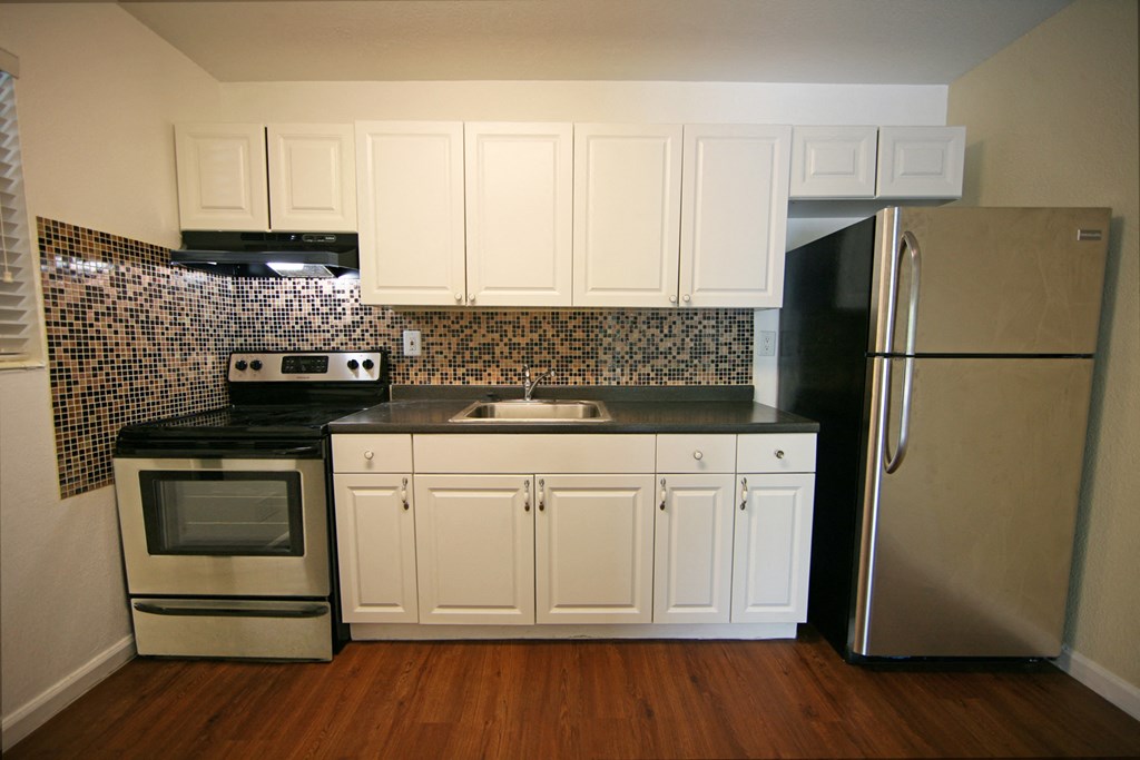 a kitchen with white cabinets and stainless steel appliances