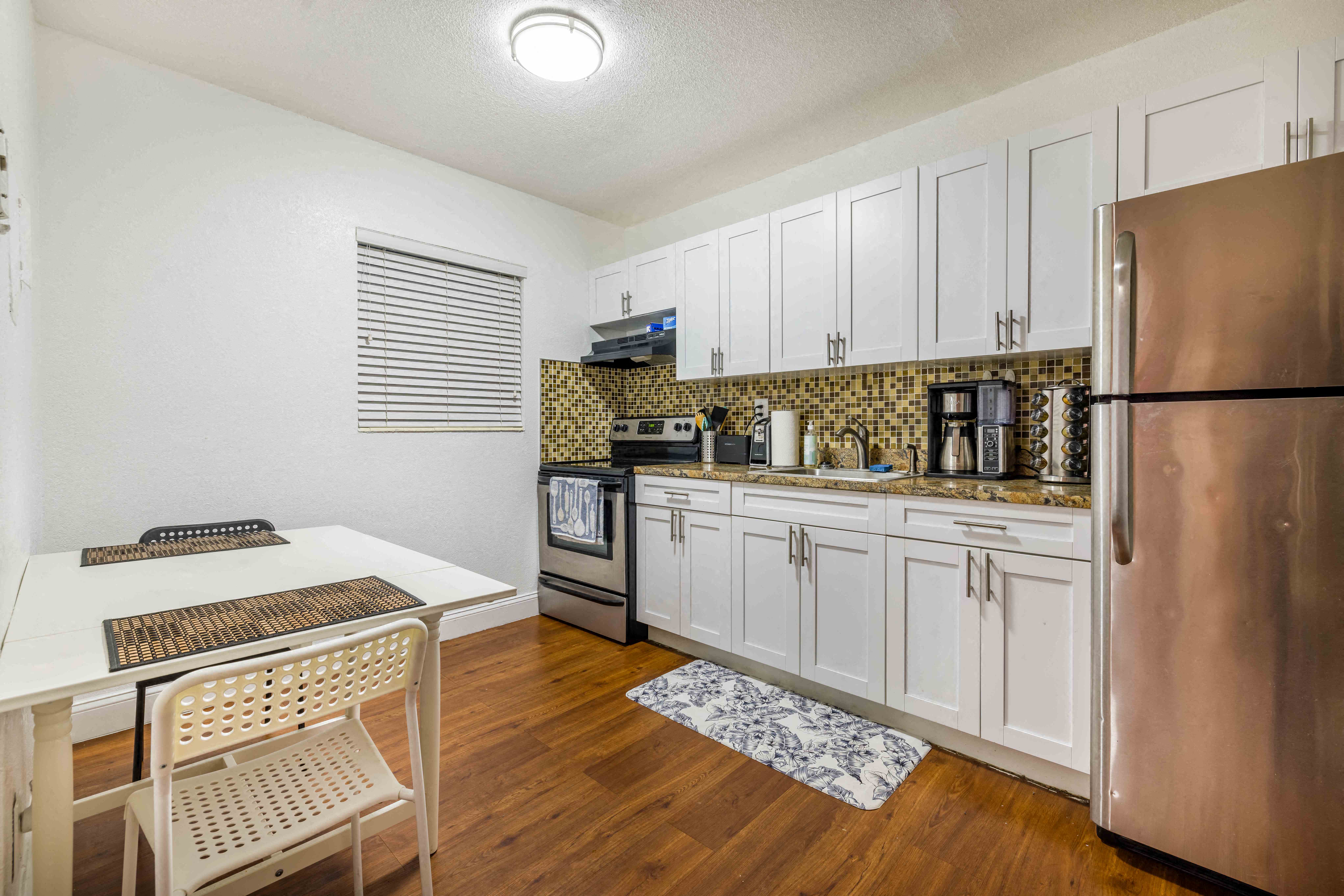 a kitchen with stainless steel appliances and a table and chairs
