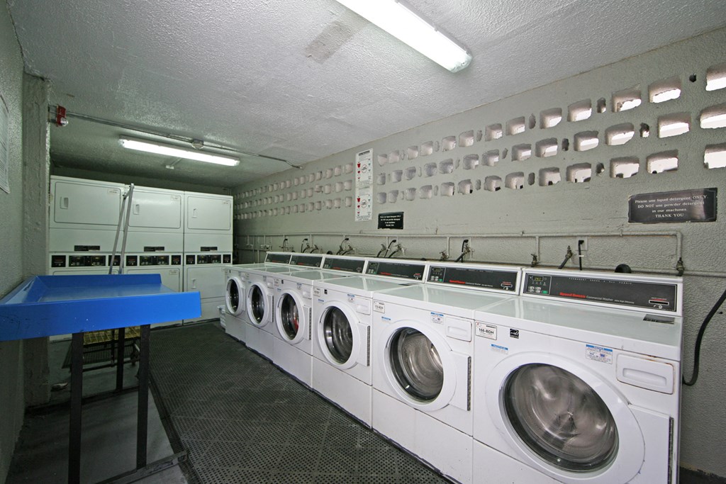 a washer and dryer room with a row of washing machines
