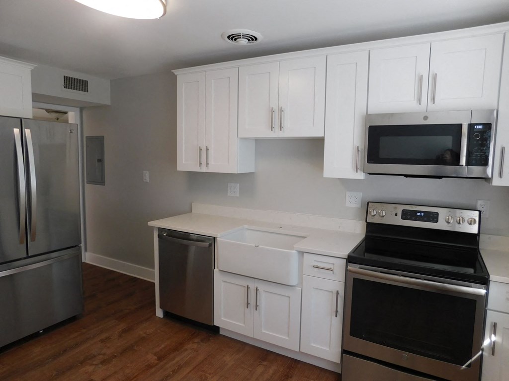 a kitchen with white cabinets and stainless steel appliances