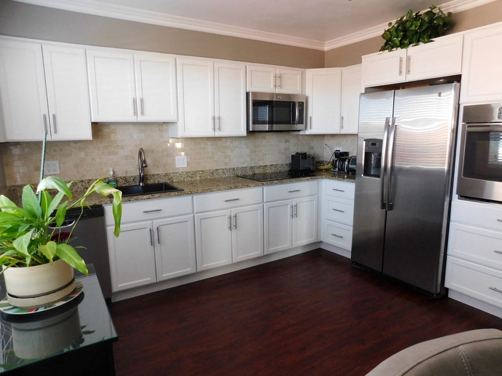 a kitchen with white cabinets and stainless steel appliances