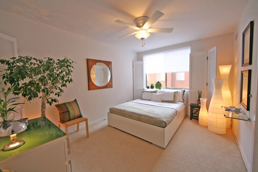 a bedroom with a bed and a ceiling fan