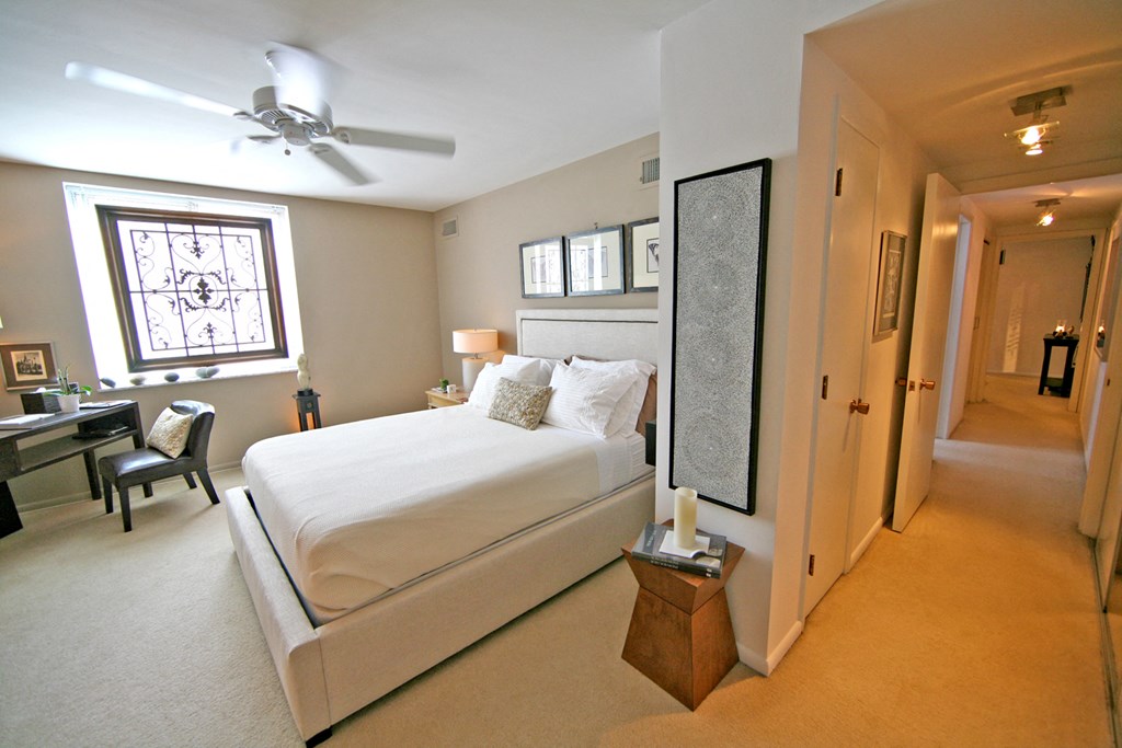a bedroom with a large white bed and a ceiling fan