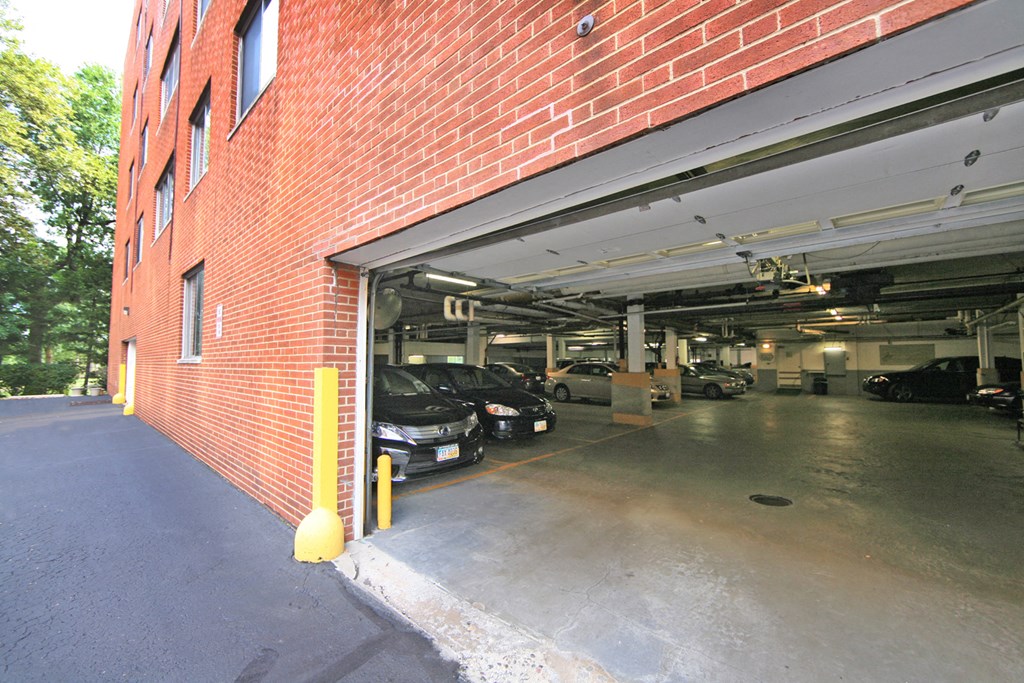 a parking garage with cars in it and a brick building