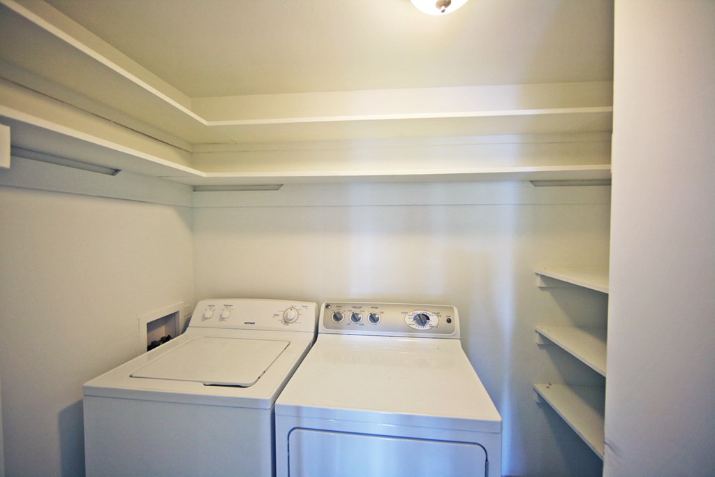 an empty laundry room with a white washer and dryer