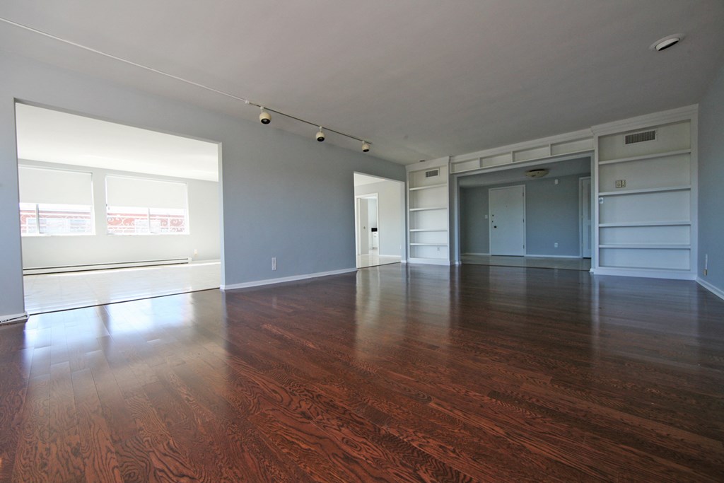 an empty living room with wood flooring and a large window