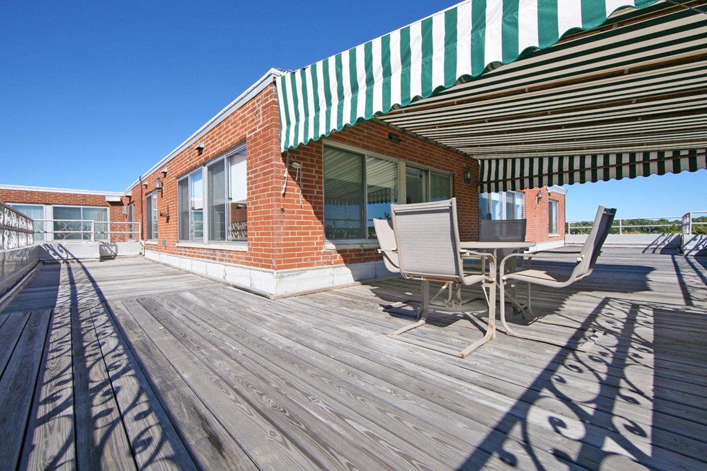 a patio with a table and chairs outside of a brick building