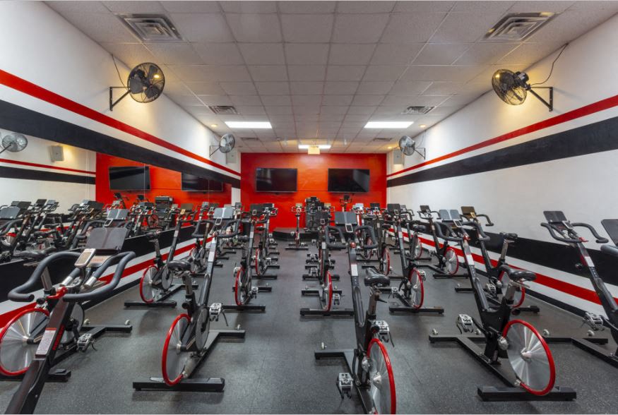 a gym with a large amount of bikes in it