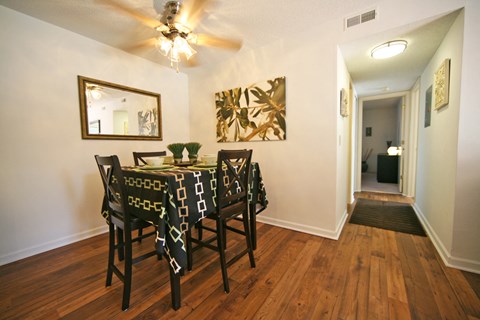 a dining room with a table and chairs and a ceiling fan
