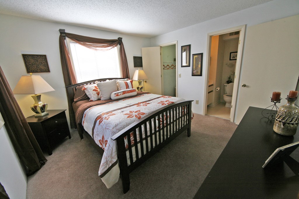 a bedroom with a bed and a window and a door to a bathroom
