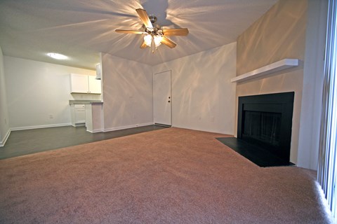 a living room with a fireplace and a ceiling fan