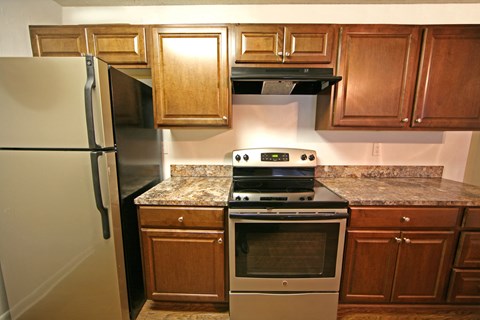 a kitchen with wooden cabinets and stainless steel appliances