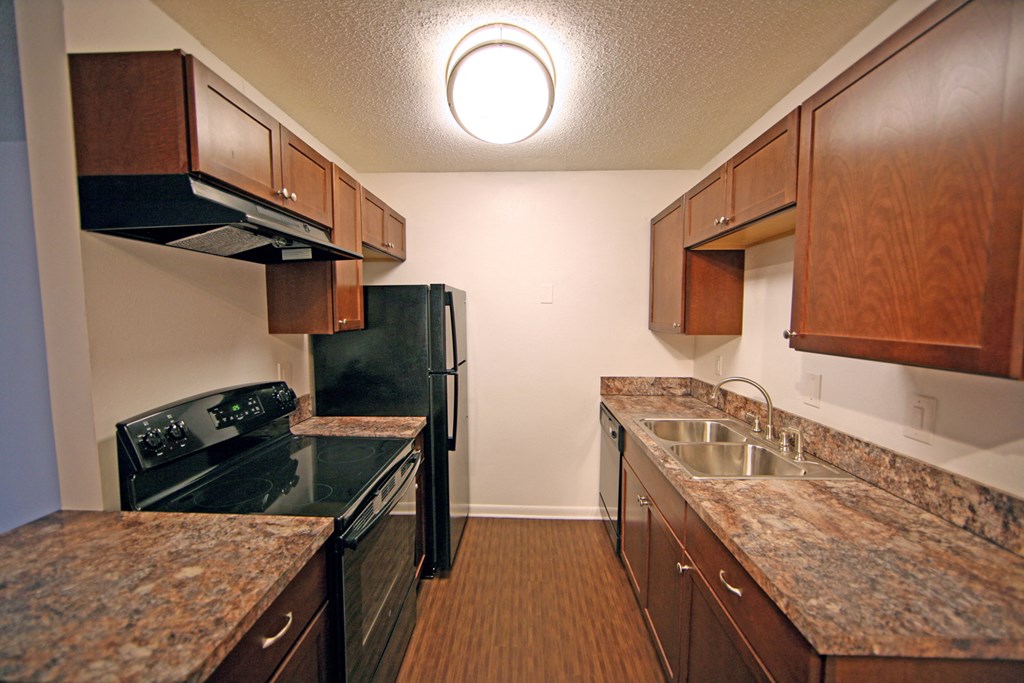 a kitchen with granite counter tops and black appliances