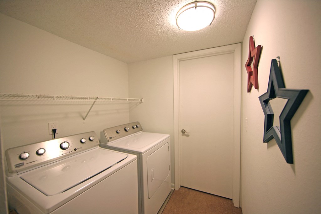 full laundry room with washer and dryer at the enclave at woodbridge apartments
