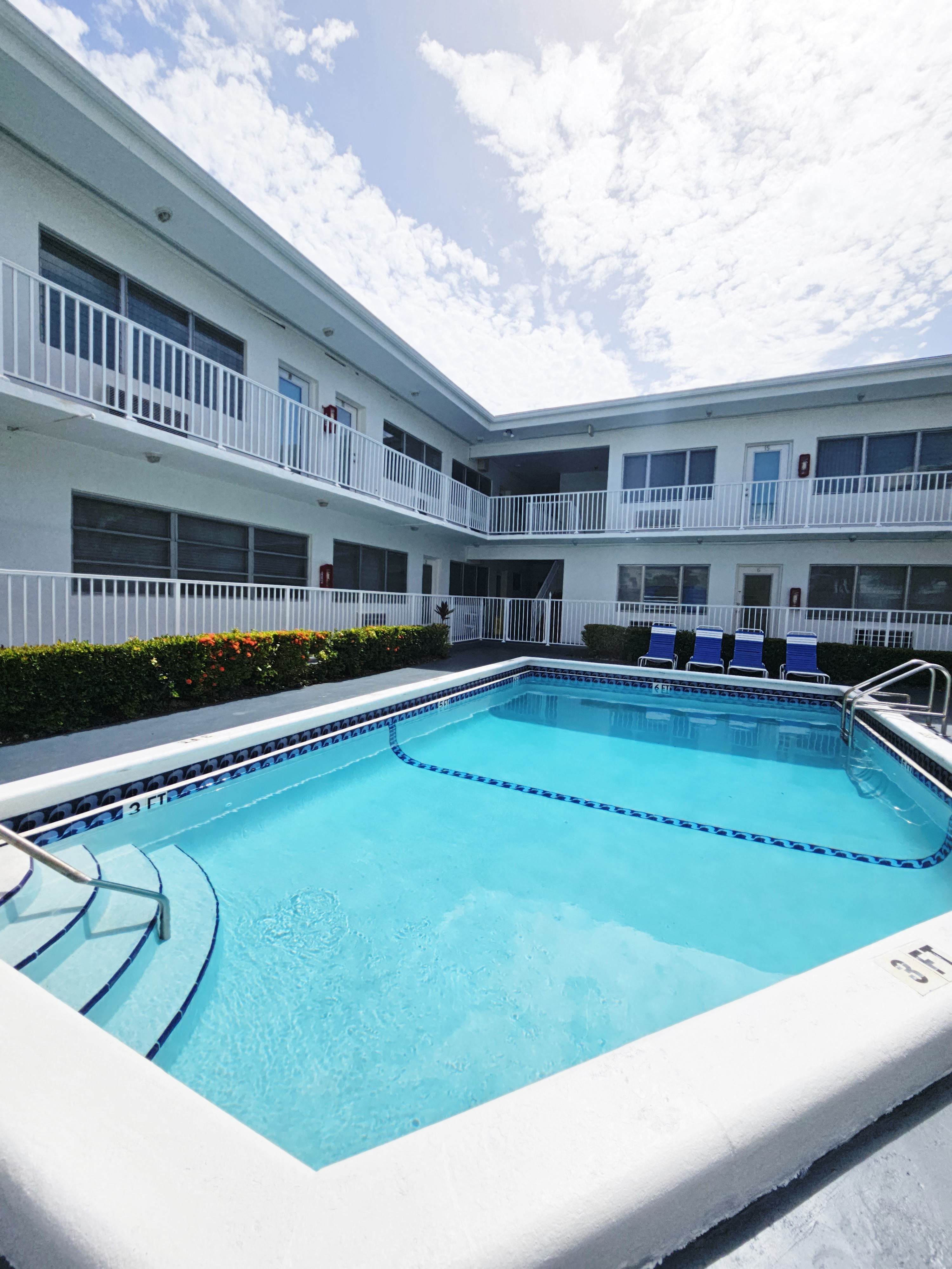 a large swimming pool in front of an apartment building