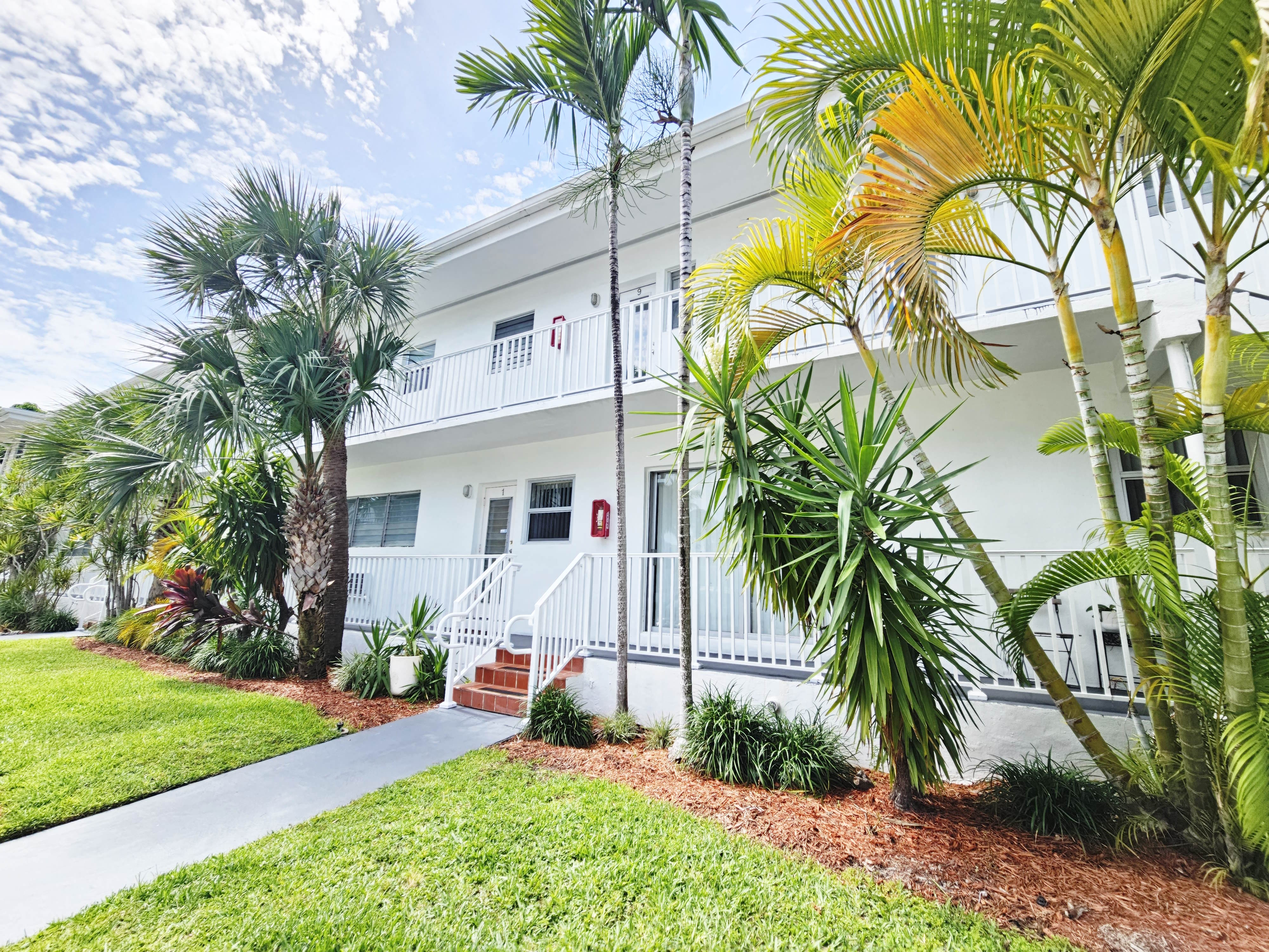 a white house with palm trees in front of it