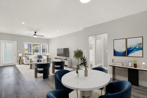 A modern living room with a white table and blue chairs.