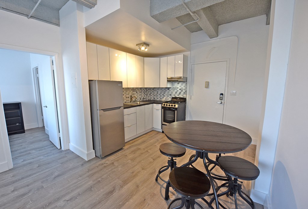 a kitchen with stainless steel appliances and a table with four stools