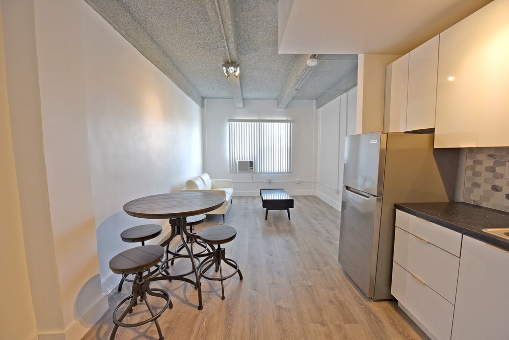 a kitchen and dining room with a small table and a refrigerator