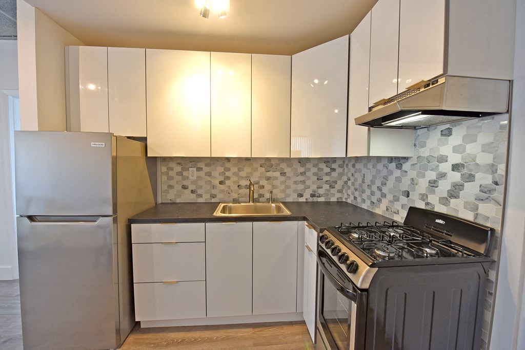 a kitchen with white cabinets and a stove and a refrigerator