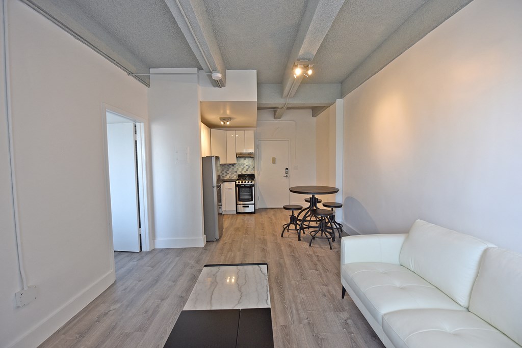 a living room and kitchen with a white couch and a table