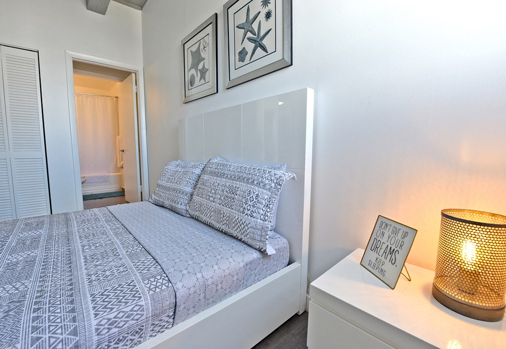 a bedroom with a bed and a table with a lamp